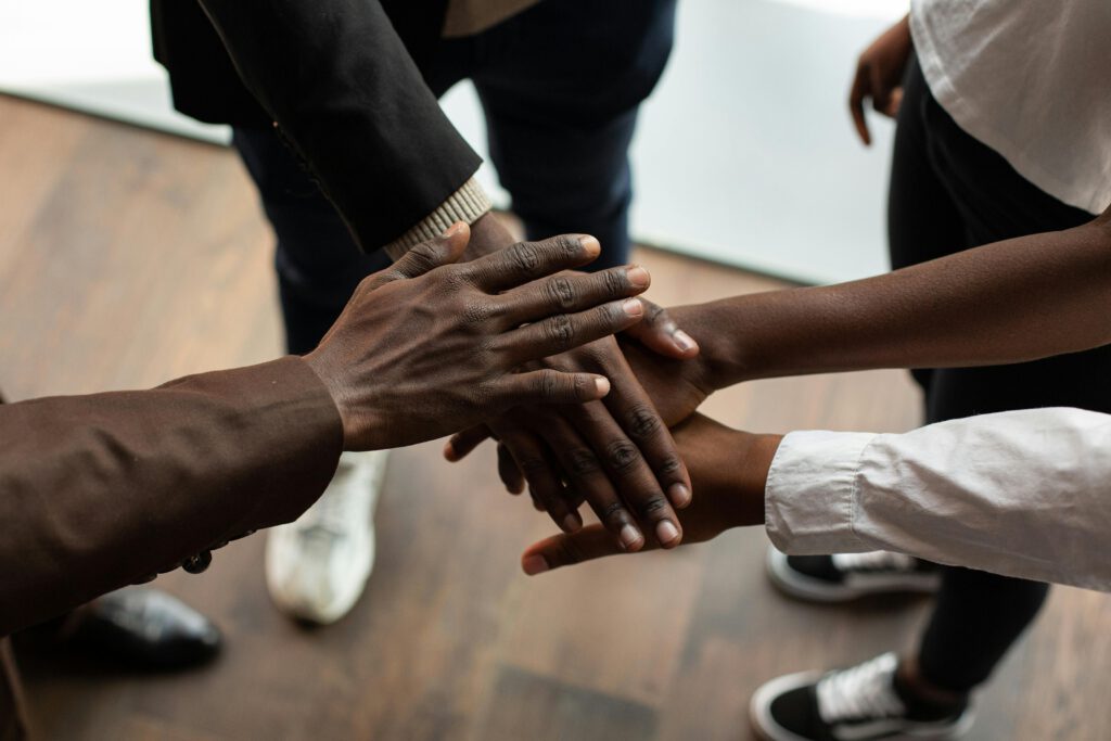 High angle view of diverse hands stacked together, symbolizing teamwork and unity.